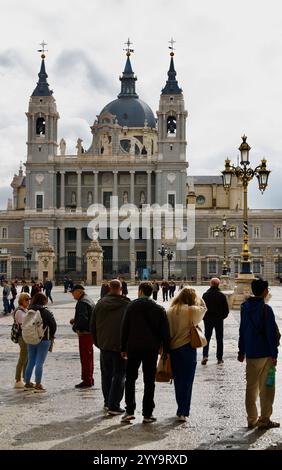 Fassade der Kathedrale von Almudena, die 1993 gegenüber dem Königspalast mit Touristen auf der Plaza de la Armería Madrid Spanien Europa fertiggestellt wurde Stockfoto