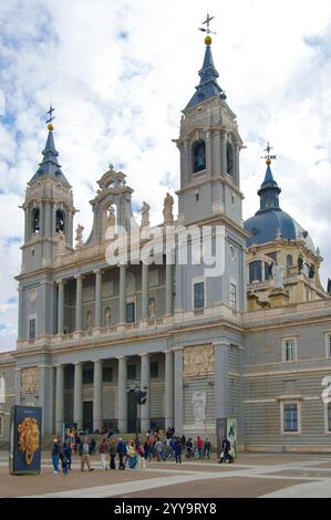 Fassade der Kathedrale von Almudena, die 1993 gegenüber dem Königspalast mit Touristen auf der Plaza de la Armería Madrid Spanien Europa fertiggestellt wurde Stockfoto