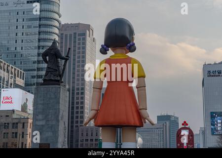 Seoul, Südkorea. Dezember 2024. Hinter Young-hee steht am 20. Dezember 2024 eine Roboterpuppe aus Netflix’s Squid Game am Gwanghwamun Square in Seoul, Südkorea. „Squid Game“ wird am 26. Dezember auf Netflix Premiere feiert. (Foto: Kichul Shin/NurPhoto) Credit: NurPhoto SRL/Alamy Live News Stockfoto