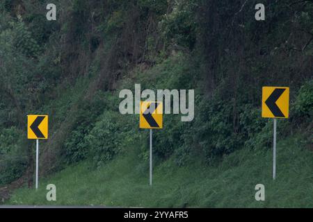 Das Pfeilschild links von einer Kurve auf der Straße zeigt die Bewegung an, die den Fahrern in dieser Spur erlaubt ist Stockfoto