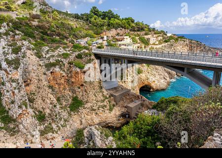 Malerische Bucht namens Ciolo mit Badenden und einer Betonbrücke, in der Gemeinde Gagliano del Capo, Provinz Lecce, Salento, Apulien, Italien Stockfoto