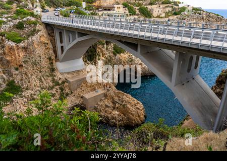 Malerische Bucht namens Ciolo mit Badenden und einer Betonbrücke, in der Gemeinde Gagliano del Capo, Provinz Lecce, Salento, Apulien, Italien Stockfoto