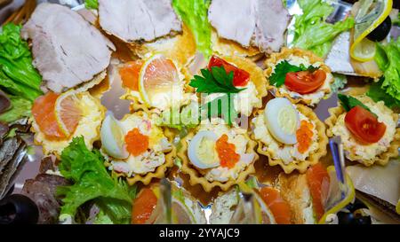 Auf der lebhaften Platte finden Sie verschiedene delikate Vorspeisen, darunter Salate, Meeresfrüchte und garnierte Torten, die für einen Nachmittag wunderschön präsentiert werden Stockfoto