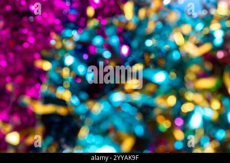 Ein lebendiger Bokeh-Hintergrund mit leuchtenden rosa, blauen und gelben Lichtern. Perfekt für Themen wie Feiern und Weihnachtsmotive. Stockfoto