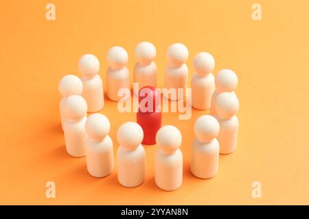 Rote menschliche Figur unter weißen auf orangem Hintergrund, Nahaufnahme. Wettbewerbskonzept Stockfoto