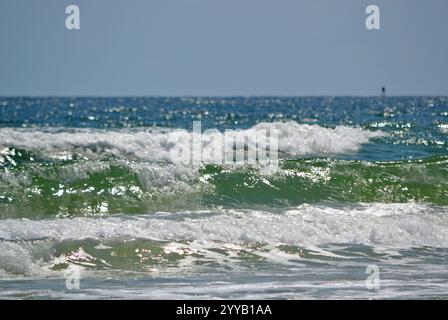 Die Wellen im Ozean am Ponce Inlet Beach, Florida, mit einer winzigen Boje am Horizont Stockfoto