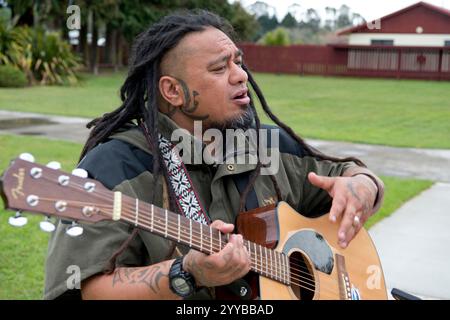 Maori-Mann spielt Gitarre und singt in Neuseeland. Stockfoto