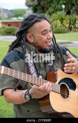 Maori-Mann singt und spielt Gitarre in Neuseeland. Stockfoto