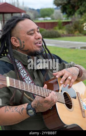 Maori-Mann singt und spielt Gitarre in Neuseeland. Stockfoto