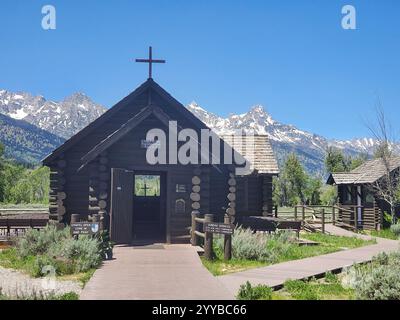 Kleine, aus Holz stammende Episcopal Chapel of the Transfiguration in der Nähe von Menor's Ferry im Grand Teton National Park in Wyoming. Die Grand Teton Bergkette ist in Th Stockfoto