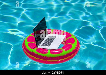 Sommergeschäft. Freelance-Stil. Fernarbeit im Swimmingpool. Sommerreisen. Geschäftsreisen im Sommerurlaub. Laptop mit leerem Bildschirm. Sommer va Stockfoto