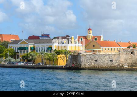 Willemstad, Curacao, Niederlande - 6. Januar 2018: Ein malerischer Blick auf farbenfrohe Kolonialgebäude und historische Befestigungsanlagen entlang Willemstads W Stockfoto