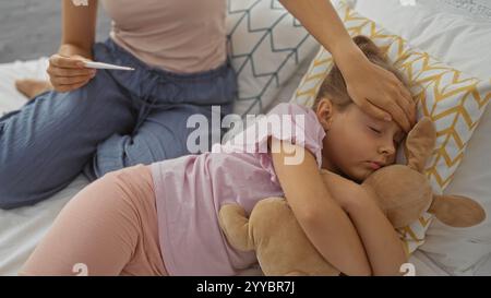 Frau tröstet kranke Tochter im Schlafzimmer, während sie Temperatur misst, Kind liegt auf Bett mit Kuschelspielzeug Stockfoto