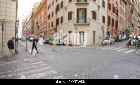 Die verschwommene Szene fängt Menschen auf einer Kopfsteinpflasterstraße in rom, italien, mit klassischer Architektur und Motorrollern ein, die eine lebendige und authentische Atmosphäre schaffen Stockfoto