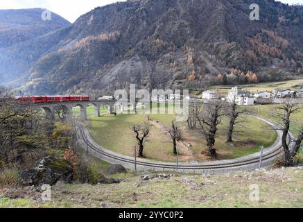 Chur. Dezember 2024. Am 3. Dezember 2024 fährt ein Zug auf dem Rundviadukt Brusio entlang der Albula-Bernina-Bahnstrecke in der Schweiz. Die seit 2008 UNESCO-Weltkulturerbe gehörende Albula-Bernina-Bahn, ein Drittel der Jahrhunderte alten Rhätischen Bahn (RhB), erstreckt sich über 122 km von Thusis (Schweiz) nach Tirano (Italien) und überquert 196 Brücken. 55 Tunnel und 20 Städte in alpinen Landschaften. Quelle: Lian Yi/Xinhua/Alamy Live News Stockfoto