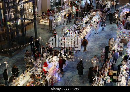 Lebhafte Marktszene mit festlichen Verkaufsständen, farbenfrohen Einkäufern und lebhafter Atmosphäre Stockfoto
