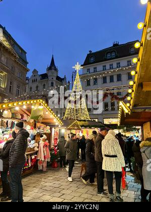 Weihnachtsmarkt am Hof im Zentrum von Wien mit beleuchtetem Weihnachtsbaum, Marktständen und Menschen. Am Abend in der Dämmerung aufgenommen. Stockfoto