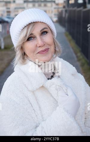 Elegante Seniorin in Winterkleidung, die draußen lächelt Stockfoto