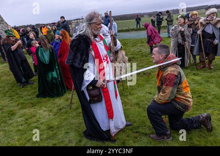 Salisbury, Großbritannien. Dezember 2024. Druiden feiern bei Sonnenaufgang am kürzesten Tag des 22. Dezember 2019. Hunderte von Menschen versammelten sich den berühmten historischen Steinkreis in Wiltshire, um den Sonnenaufgang an der Wintersonnenwende zu feiern, dem kürzesten Tag des Jahres. Die Veranstaltung ist im heidnischen Kalender wichtiger als die Sommersonnenwende, weil sie die Wiedergeburt der Sonne für das kommende Jahr markiert. Credit: David Betteridge/Alamy Live News Stockfoto