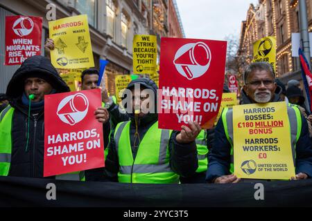 London, UK, 21. Dezember 2024. Demonstranten halten Protestzeichen hoch. Mitglieder der UVW union halten eine Demonstration vor dem weltberühmten Londoner Kaufhaus Harrods ab. Restaurantpersonal, Reinigungspersonal und Sicherheitsbeamte halten an einem der geschäftigsten Einkaufstage des Jahres eine Streikschlange vor dem Haupteingang. Die UVW-gewerkschaft fordert, dass ihren Mitgliedern ein versprochener Weihnachtsbonus, eine Erhöhung der Regellöhne und eine Verbesserung der allgemeinen Arbeitsbedingungen gezahlt wird. Quelle: James Willoughby/ALAMY Live News Stockfoto