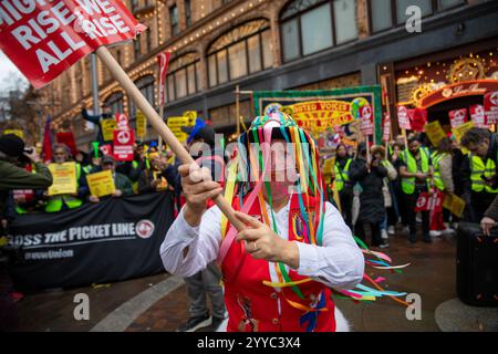 London, UK, 21. Dezember 2024. Ein Demonstrant hält ein Protestzeichen hoch. Mitglieder der UVW union halten eine Demonstration vor dem weltberühmten Londoner Kaufhaus Harrods ab. Restaurantpersonal, Reinigungspersonal und Sicherheitsbeamte halten an einem der geschäftigsten Einkaufstage des Jahres eine Streikschlange vor dem Haupteingang. Die UVW-gewerkschaft fordert, dass ihren Mitgliedern ein versprochener Weihnachtsbonus, eine Erhöhung der Regellöhne und eine Verbesserung der allgemeinen Arbeitsbedingungen gezahlt wird. Quelle: James Willoughby/ALAMY Live News Stockfoto