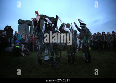 Salisbury, England, Großbritannien. Dezember 2024. Die White Horse Morris Group tritt während der Wintersonnenfeier für die Menschenmassen auf. Die Wintersonnenwende 2024 markiert sowohl den kürzesten Tag als auch die längste Nacht des Jahres. Die Sonnenwende ist auch der Beginn des historischen heidnischen Festivals Yule. Stonehenge wurde gebaut, um sich an den Sonnenzeiten an der Sonne auszurichten. (Kreditbild: © Martin Pope/ZUMA Press Wire) NUR REDAKTIONELLE VERWENDUNG! Nicht für kommerzielle ZWECKE! Quelle: ZUMA Press, Inc./Alamy Live News Stockfoto