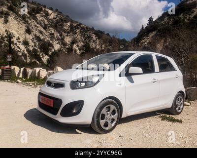 KOILI, ZYPERN - 22. FEBRUAR 2024: Weißer Kleinwagen Kia Picanto SA parkt auf dem Parkplatz der Adonis Baths Stockfoto