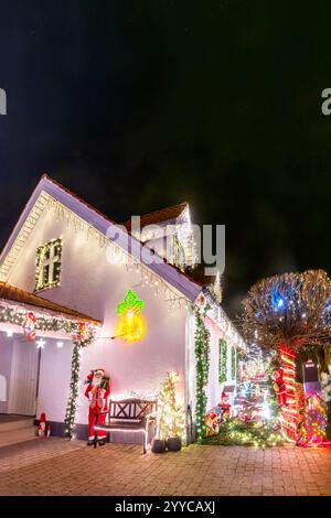 Eine Straße mit bunt dekorierten Häusern mit Weihnachtsbeleuchtung in Hinnerup, Jütland, Dänemark. Stockfoto