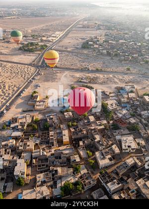 Heißluftballons fliegen über das Tal der Könige, Luxor, Ägypten vor der Kulisse des Himmels und der Hügel - Hochwinkelaufnahme Stockfoto
