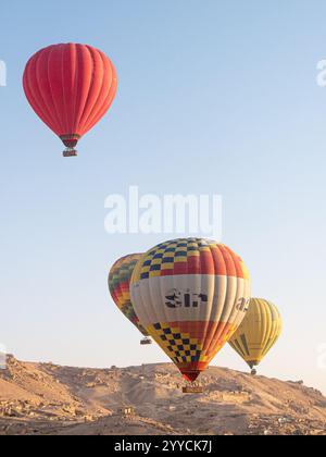 Heißluftballons fliegen über das Tal der Könige, Luxor, Ägypten vor der Kulisse des Himmels und der Hügel - Portrait Shot Stockfoto