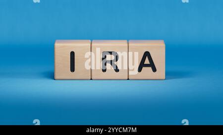 IRA individuelles Pensionskonto Wort auf Holzwürfelblock. Nahaufnahme von Holzelementen, Business Concept.3D-Rendering auf blauem Hintergrund. Stockfoto