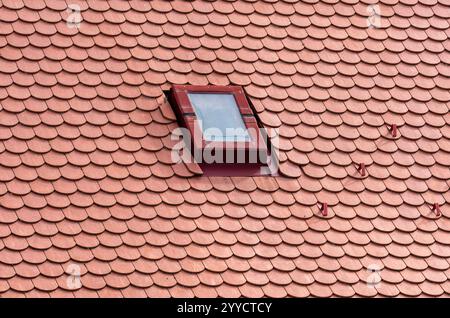 Gerahmte Stille: Fenster auf rotem Dach Stockfoto
