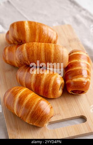 Hausgemachte Wurstbrötchen auf einem Bambusbrett, Seitenansicht. Stockfoto