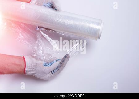 Verpackungsmaterial. Stretchfolie und Kartonverpackung auf weißem Hintergrund. Verpacken der Waren vor dem Versand. Stockfoto