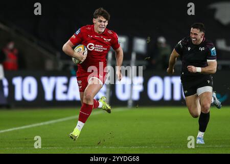 Swansea, Großbritannien. Dezember 2024. Eddie James von Scarlets beim Angriff während des Spiels Ospreys gegen Scarlets United Rugby Championship. Gruffydd Thomas/Alamy Stockfoto