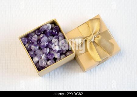 Set aus verschiedenen natürlichen Amethyst-Mineralsteinen und Edelsteinen auf violettem Hintergrund, teilweise fokussiert von oben Stockfoto