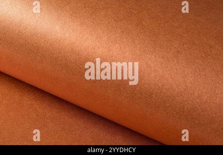 Kupfer- und Rostpapierstruktur mit metallischer, satinierter Oberfläche und dezentem Farbverlauf. Die warmen Erdtöne von Orange, Braun und Terrakotta sorgen für ein helles Licht Stockfoto