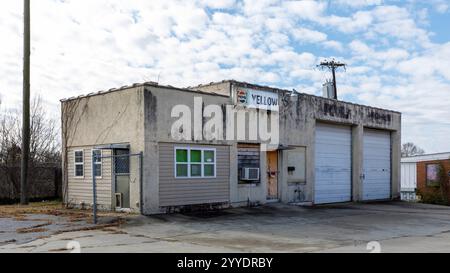 Hickory, North Carolina, USA-19. Dezember 2024: Verlassene Autogarage, zuletzt als Taxidienst genutzt. Ein Teil des Schilds „gelbe Kabine“ bleibt erhalten. Stockfoto