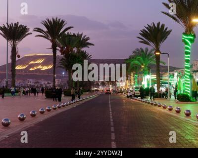 Straße neben der Promenade mit Palmen in Agadir mit der Kasbah (Fort) von Agadir Oufla dahinter. Stadt Agadir, 21. Dezember 2024 Stockfoto