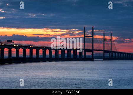 Sonnenuntergang über der M4 Second Severn Crossing, heute Prince of Wales Bridge genannt, von Aust Side in England, Großbritannien, mit Ampeln vom Verkehr auf der Brücke Stockfoto