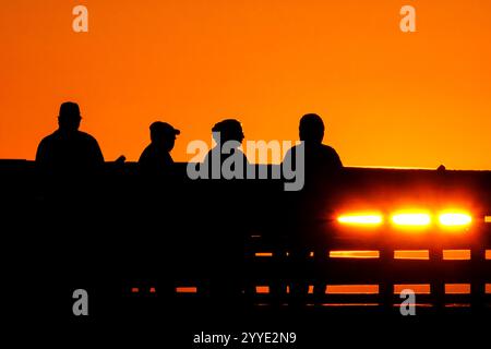 Isle Of Palms, Usa. Dezember 2024. Eine Gruppe von Menschen beobachtet den Sonnenaufgang an einem kalten Morgen zur Wintersonnenwende vom Isle of Palms Pier, 21. Dezember 2024 in Isle of Palms, South Carolina. Die Wintersonnenwende ist der kürzeste Tag der nördlichen Hemisphäre und markiert den Beginn des Winters. Quelle: Richard Ellis/Richard Ellis/Alamy Live News Stockfoto