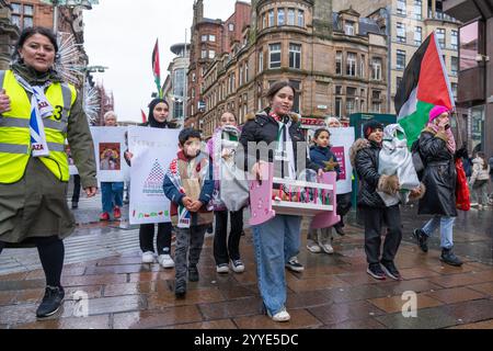 Glasgow, Schottland, Großbritannien. Dezember 2024. Krippenprozession von der Statue La Pasionaria zu den Stufen von Buchanan, gefolgt von einem Spaziergang entlang der Buchannan Street und Weihnachtsliedern mit Worten für Frieden und Gerechtigkeit, in der Hoffnung auf ein Ende des Leidens für das palästinensische Volk. Gutschrift R.. Gass/Alamy Live News Stockfoto