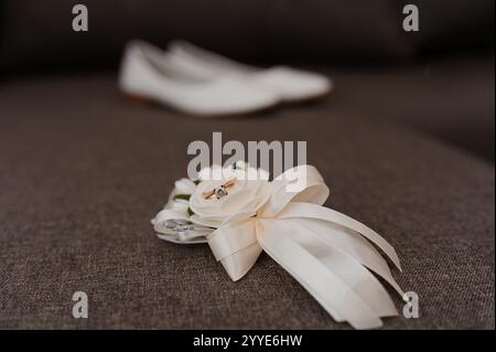 Elegante Brautaccessoires mit Hochzeitsschuhen und Blumenarrangements. Stockfoto