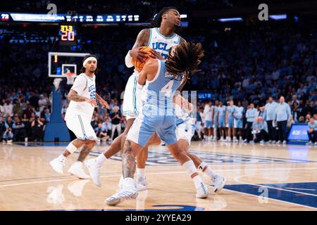 New York, New York, USA. Dezember 2024. Der UCLA Bruins-Wachmann Sebastian Mack (12) zieht in der zweiten Halbzeit ein Foul auf dem North Carolina Tar Heels-Wachmann RJ DAVIS (4). (Kreditbild: © Jordan Bank/ZUMA Press Wire) NUR REDAKTIONELLE VERWENDUNG! Nicht für kommerzielle ZWECKE! Stockfoto