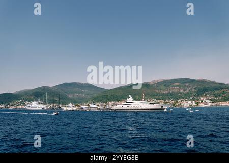 Eine kleine Motoryacht segelt auf dem Meer vorbei an einer riesigen Superyacht. Hochwertige Fotos Stockfoto