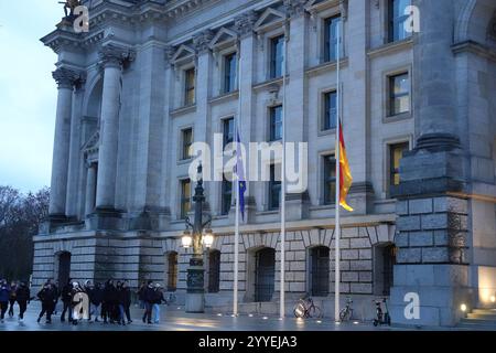 Berlin, Deutschland. Dezember 2024. Fahnen fliegen auf Halbmast beim Deutschen Bundestag in Berlin, 21. Dezember 2024. Bundesinnenministerin Nancy Faeser ordnete am Samstagmorgen an, dass alle Fahnen an allen Bundesgebäuden bundesweit auf Halbmast geflogen werden, um die Opfer eines tragischen Angriffs auf einen Weihnachtsmarkt in Magdeburg am Freitagabend zu betrauern, auf dem ein Auto in eine Menschenmenge rammte, mindestens fünf Menschen tötete und 200 weitere verletzte. Quelle: Liu Yang/Xinhua/Alamy Live News Stockfoto