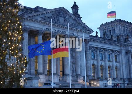 Berlin, Deutschland. Dezember 2024. Fahnen fliegen auf Halbmast beim Deutschen Bundestag in Berlin, 21. Dezember 2024. Bundesinnenministerin Nancy Faeser ordnete am Samstagmorgen an, dass alle Fahnen an allen Bundesgebäuden bundesweit auf Halbmast geflogen werden, um die Opfer eines tragischen Angriffs auf einen Weihnachtsmarkt in Magdeburg am Freitagabend zu betrauern, auf dem ein Auto in eine Menschenmenge rammte, mindestens fünf Menschen tötete und 200 weitere verletzte. Quelle: Liu Yang/Xinhua/Alamy Live News Stockfoto