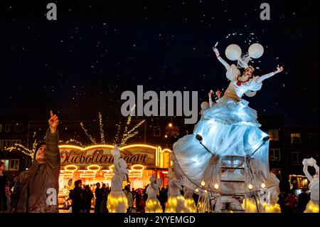 Nijmegen, Niederlande. Dezember 2024. Ein kleiner Junge schaut sich die Federn an, die von einer Tänzerin geworfen wurden. Die Weihnachtszeit begann in Nijmegen mit einer wunderschönen Winterparade, die aus einer Gruppe akrobatischer Künstler bestand, die auf speziellen Fahrrädern auftraten und jungen Leuten, die mit Lichtern tanzen, bestand. Sobald er am Grote Market angekommen ist, zündet Stadtrat John Brom den Weihnachtsbaum an. Die Winterwunderparade ist Teil der Winterwochen in Nijmegen, die mit verschiedenen Aktivitäten für Kinder einhergehen. Quelle: SOPA Images Limited/Alamy Live News Stockfoto