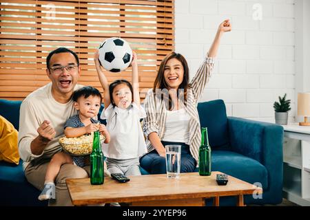 Eine glückliche Familie genießt den Nervenkitzel eines Fußballspiels zu Hause Stockfoto