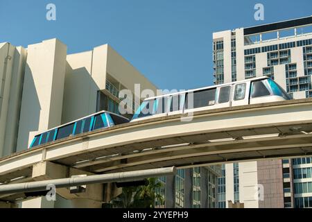 Stadtverkehr im Stadtteil Miami Brickell in Florida, USA. Metrorail-Stadtzug auf der Hochbahn über Straßenverkehr zwischen Stockfoto